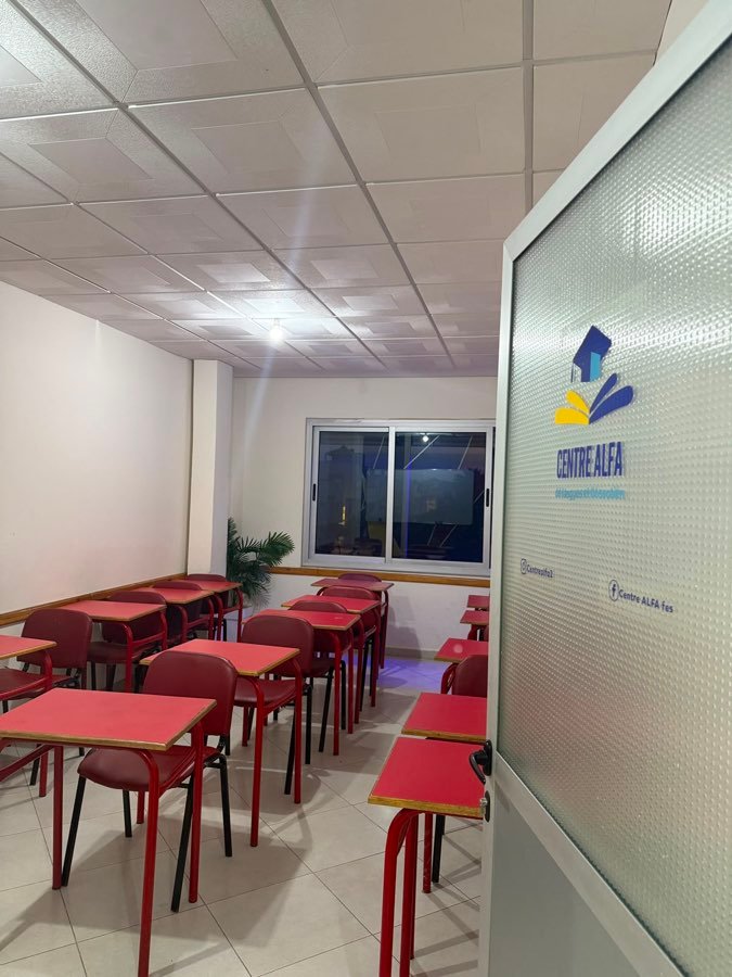 Salle avec tables rouges et mur géométrique bleu, rouge et jaune