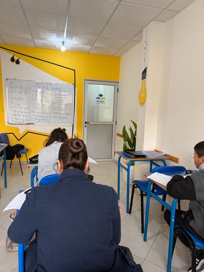 Des élèves faisant des exercices à leur table devant le mur jaune