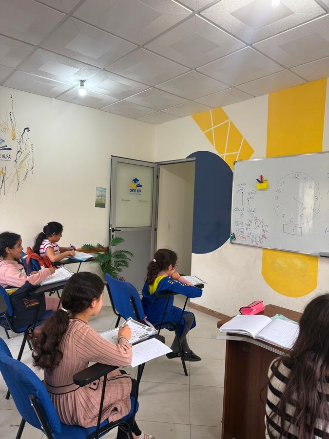 De jeunes élèves apprenant à lire l'heure dans une salle du Centre Alfa